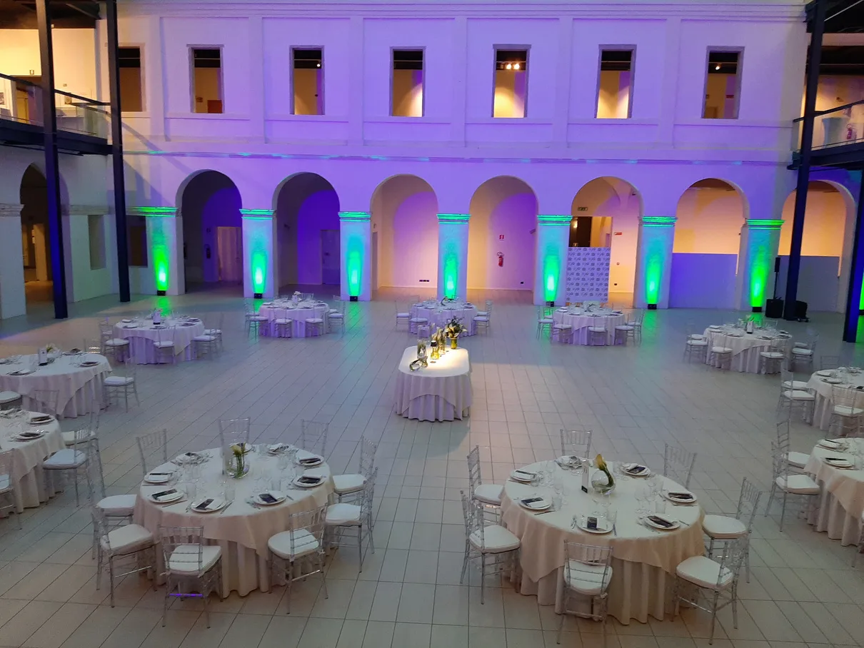 Sala allestita per la cena di gala con tavoli rotondi e illuminazione scenografica